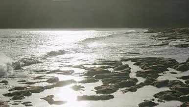 耀眼阳光清澈海浪冲刷海岸视频的预览图